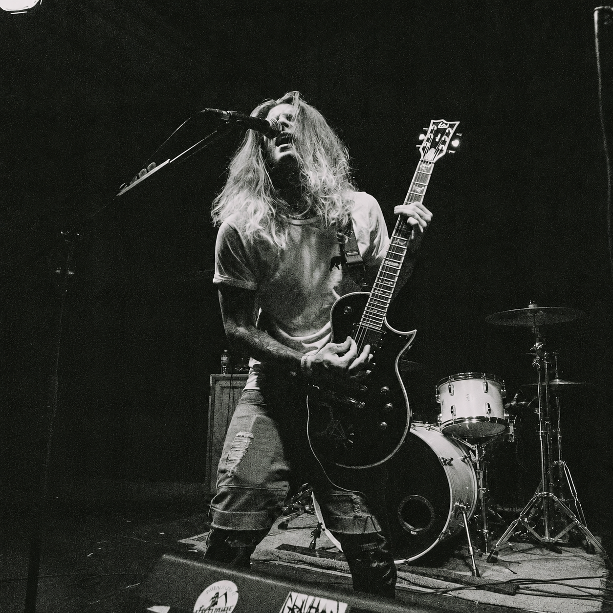 Jackson Downer singing and playing guitar live onstage